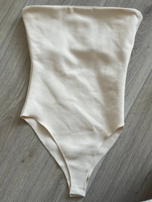 Body från Zara - Säljer den här jättegulliga bodyn från Zara. Köpt på Vinted helt oanvänd med prislapp, tagit av prislappen nu o har endast testat den💕Den är typ crèmevit