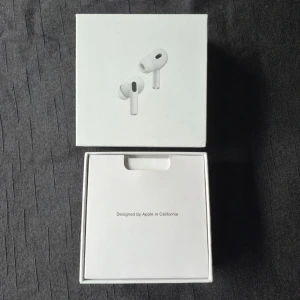 Apple AirPods Pro trådlösa hörlurar - Säljer ett par vita Apple AirPods Pro med laddningsetui. Hörlurarna har en stilren och kompakt design med silikonproppar för bra passform. Perfekta för dig som vill ha brusreducering och smidig anslutning till iPhone eller andra Apple-enheter.
