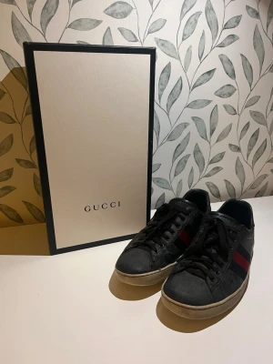 Gucci skor - Ett par gucci ace skor i bra skick inga synliga defekter vid användning. Förutom ett litet hål på undersidan (se bild 3) man får med både lådan och 2 dustbags. Pris går att diskutera. Tvättar även skorna noggrant innnan de skickas! Har man fler frågor skriv gärna 