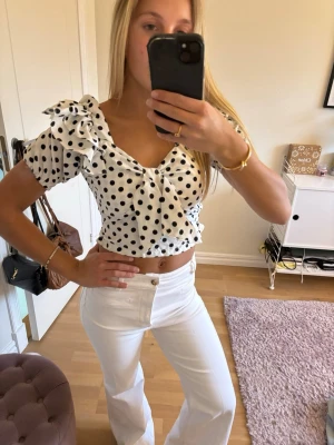 Vit prickig croppad blus med rosett - Jätte söt prickig topp, står ingen storlek i men passar mig som vanligtvis har storlek xs/s