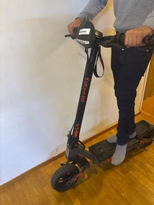 Kugoo Kirin G2 el-scooter svart/orange - Säljer en el-scooter Kugoo Kirin G2 i svart med orange detaljer. Scootern har robust ram, stora luftfyllda däck, integrerat bakljus och förstärkt tail pedal. Plattformen är täckt för extra vattenskydd och framgaffeln är stabil och tålig. Perfekt för smidig transport.