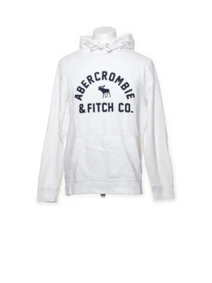 Abercrombie & Fitch - Snygg vit hoodie från Abercrombie & Fitch med stor logga och älgtryck på bröstet. Klassisk känguruficka framtill, justerbar huva med dragsko och ribbade muddar. Tillverkad i mjukt bomullsmaterial för extra komfort.