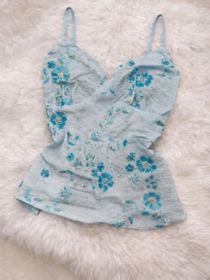 Beautiful Y2K light blue top with floral embroidery and pearl details  - Gives strong Ibiza / beach club / summer night vibes 🌊💙 Perfect for vacation, sunset dinners, beach parties or festivals. Easy to style with linen pants, low-rise jeans or a flowy skirt.  • Condition: very good • Size: XS–S • Color: light blue • Style: Y2K / Ibiza / Couquette / Fairy  Fast shipping 💌  y2k, ibiza style, summer top, embroidered top, pearl top, light blue top, vacation outfit, 2000s, spaghetti strap top 