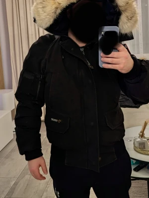 Canada Goose chilliwack bomber, S! - Säljer en svart parkas från Canada Goose med stor och fluffig päls.. Jackan har flera fickor, patch på ärmen och dragkedja med knappslå. Perfekt för kalla dagar och riktigt snygg streetstil. Canada Goose Chilliwack bomber! Klassisk jacka med enorm päls vilket är ovanligt för denna modellen. Storlek, passar en som bär S perfekt. Priset är fast, respektera det tack.