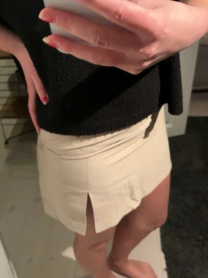 Khaki/ beige  kortkjol med slits - Stilren beige och khaki färgad kortkjol med rak passform och en snygg slits framtill. Kjolen har minimalistisk design och är perfekt att matcha med olika toppar, jätte fin med ett vitt linne. Säljer endast då jag beställde den och den var för liten