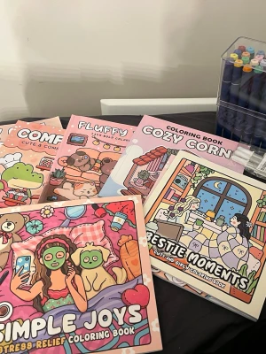 Färgglada målarböcker med gulliga motiv - Säljer flera målarböcker med söta och mysiga illustrationer, perfekta för avkoppling och kreativitet. Omslagen är färgglada med motiv av djur, vänner och vardagsscener. Böckerna har mjuka pärmar och är fyllda med detaljerade bilder att färglägga. Pennorna är använda sen jul. Vissa böcker är målade