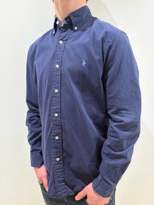Mörkblå Ralph lauren skjorta - strl S - Ralph Lauren skjorta 👔✨ Mörkblå med ljusblå logga 💙 Storlek S 👀 Snygg passform som funkar både uppklätt och mer avslappnat 😎🔥 Klassisk och tidlös design Kolla in profilen för flera feta Ralph Lauren skjortor 👀🔥 Hör av er om ni har frågor eller vill ha fler bilder 💬