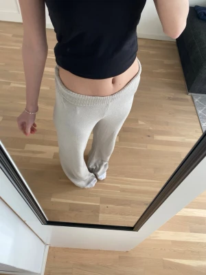 Beiga stickade loungebyxor - Mysiga beiga loungebyxor med bred resår i midjan och raka ben. Byxorna är stickade och har en avslappnad passform, perfekta för chill dagar hemma. Materialet ser mjukt och bekvämt ut, perfekt för loungewear.