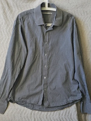 Rutig skjorta från Frank Q, XL - Klassisk svartvit rutig skjorta från Frank Q i storlek XL. Skjortan har lång ärm, knappar framtill och en snygg krage. Tillverkad i mjuk bomull som känns skön mot huden. Perfekt för dig som gillar stilrena och tidlösa plagg.