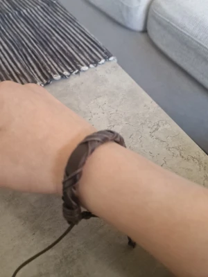 läderarmband - Snyggt brunt armband i flätat läder med justerbar knytning. Armbandet har en avslappnad och stilren look som passar perfekt till vardagsoutfiten. Materialet är mjukt och bekvämt mot huden.