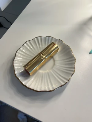 Rött läppstift från L'Oréal Paris - Snyggt rött läppstift från L'Oréal Paris med elegant guldfärgat hölje. Läppstiftet har en klassisk spetsig form och ger en intensiv röd färg till läpparna. Perfekt för dig som vill ha en tidlös och lyxig look. Pris kan diskuteras, aldrig använt!