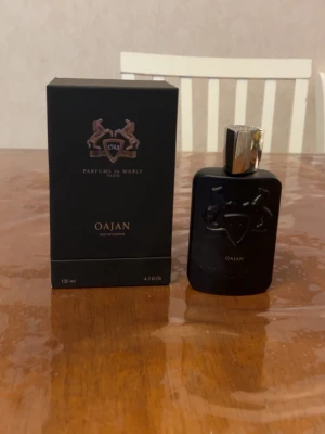 Parfums de Marly Oajan Eau de Parfum - Oajan Eau de Parfum från Parfums de Marly i en elegant svart flaska med silverfärgad kork och snyggt reliefmönster. Flaskan rymmer 125 ml och kommer med originalkartong. Perfekt för dig som gillar lyxiga och unika dofter.