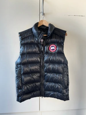  Canada Goose crofton väst - Den är i nyskick, syns inte att den är använd. Köpt från johnells, kvitto finns och medföljs. Nypris ca 8000kr. För mer frågor eller bilder är det bara att höra av sig
