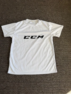 CCM t-shirt - Snygg vit t-shirt från CCM med svart logotyp på bröstet. Klassisk rund hals och korta ärmar. Tillverkad i ett lätt och bekvämt material som passar perfekt till vardags eller träning.