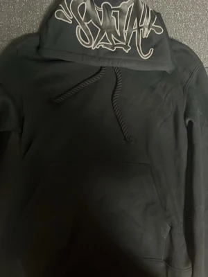 Syna world tracksuit - Svart syna world tracksuit. Med Syna påse, keychain och sticker. Säljer den eftersom hoodien var för kort för mig. Helt ny oanvänd.