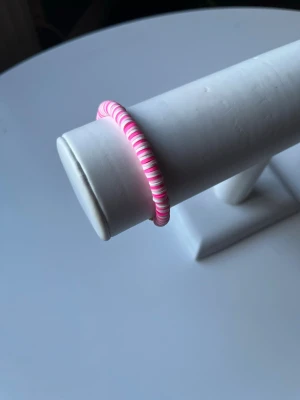 Rosavitt armband  -  Ett rosa vitt armband som har elastiskt band och även ett guldlås så att man kan också knäppa armbandet. Armbandet är handgjort.