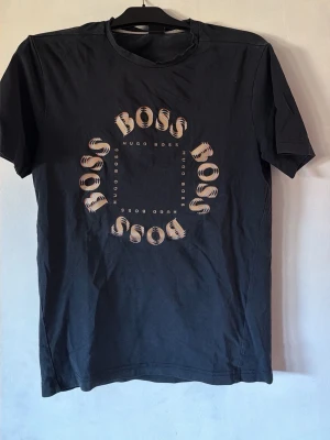Svart Hugo Boss t-shirt med tryck - Hugo boss T-shirt något år gammal men sparsamt använd 