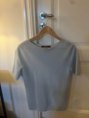 Ljusgrå kashmirtröja från Lisa Yang - Superskön ljusgrå topp i 100% kashmir från Lisa Yang. Enkel och stilren design med rund halsringning och korta ärmar. Perfekt för dig som gillar mjuka material och minimalistisk stil.