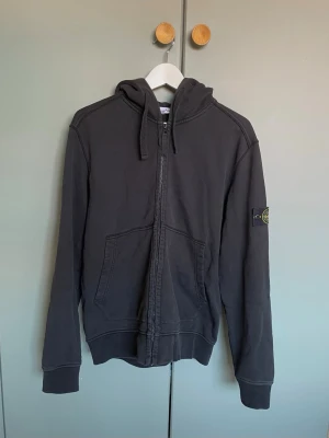 Stone Island zip hoodie  - Stone Island zip up hoodie | Fint skick, svart i storlek: L,  passar även M | Ett  litet slitage på baksidan som syns på bild 3. En populär modell där nypriset ligger norr om 3000 kr. Självklart äkta till skillnad från många andra, priset ej hugget i sten!🪨⚽️