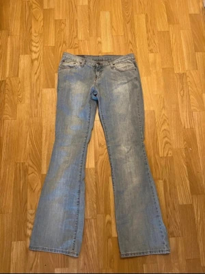 Ljusblå bootcut jeans - Säljer ett par ljusblå bootcut jeans med klassisk femficksdesign och låg midja. Passar längre person S/M. Knappt använda, som i nyskick.