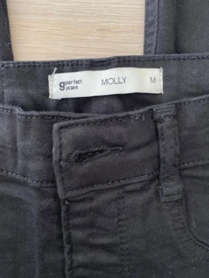 Svarta Molly jeans från Perfect Jeans - Säljer ett par svarta Molly jeans från Perfect Jeans. De har klassisk femficksdesign, smal passform och är tillverkade i ett stretchigt material som sitter snyggt. Perfekta till alla typer av outfits och superbekväma att bära.