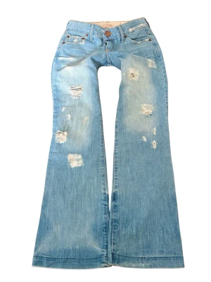 Ljusblå vintage slitna bootcut jeans - Sååå sjukt snygga vintage ljusblå bootcut jeans med slitna detaljer och hål! 