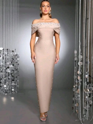 Beige axelbandslös långklänning med pärlor - Elegant beige långklänning med axelbandslös design och dekorativa pärlor över hela klänningen samt på den breda överdelen. Klänningen har figurnära passform och är perfekt för speciella tillfällen. Använd en gång, för bilder skriv gärna!💕