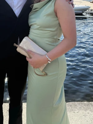 Grön adoore klänning - Ljusgrön klänning från adoore, perfekt till bal eller bröllop! Klänningen är endast använd en gång men har 2 fläckar upptill (syns på bild 2). Ej testat att ta bort då jag är okunnig om hur tyget reagerar på det🌸