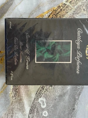 Cattleya Summer Of Kiruna Parfym 100ml - Parfymen Summer Of Kiruna från Cattleya Perfumes är en Eau De Parfum för kvinnor. Flaskan rymmer 100 ml och kommer i en elegant svart förpackning med gröna detaljer. Tillverkad i Sverige och innehåller bland annat limonene, linalool och geraniol.