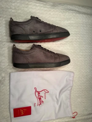Gråa sneakers från Christian Louboutin - Snygga loubs i mocka imitation. Skorna är i bra skick perfekt till våren.                                                             Tveka inte på att höra av dig vid frågor eller funderingar. Pris kan diskuteras vid snabb affär.
