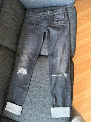 Replay Brigidot Jeans  - Säljer ett par grå Replay jeans i stretch, med fina detaljer, i mycket bra skick. Dom är dock slitna längst ner på byxbenet, på baksidan på kanten. Finns bild. 