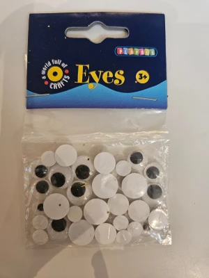 Rörliga ögon från Playbox - Ett paket med rörliga ögon i olika storlekar från Playbox. Perfekt till pyssel och DIY-projekt. Ögonen är vita med svarta pupiller och kommer i en genomskinlig plastpåse. Passar för kreativa projekt och dekorationer.