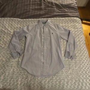 Randig skjorta från Polo Ralph Lauren - säljer en blå och vitrandig skjorta från Polo Ralph Lauren i storlek small. Mycket fint skick!