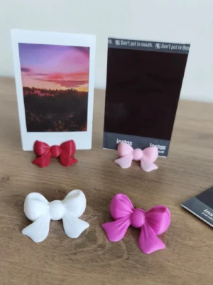 Polaroid hållare rosett - Hållare som gör så att man kan ha polarid bilder på display såsom på sminkbordet eller hylla osv, priset är för 2 st. Skicka meddelande för köp och val av färg! 