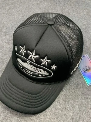 Svart keps med mesh och brodyr - Cool svart keps från Trapstar med mesh på sidorna och broderad design framtill med stjärnor och motiv. Justerbar baktill för perfekt passform. Perfekt för dig som vill ha en streetstyle-look.