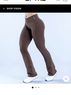 Vison flares leggings från DFYNE - Utsvängda leggings i brun färg från DFYNE med hög midja och logotyp på linningen. Stretchigt material som formar sig efter kroppen och ger en snygg siluett. Perfekta för dig som vill ha både komfort och stil. Storlek M tall, perfekt längd på mig som är ca 178, använda 2 gånger