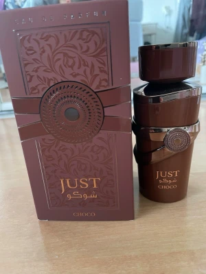Just Choco parfym från Fragrance World - Just Choco är en parfym med lyxig brun flaska och matchande ask, dekorerad med eleganta mönster och guldfärgade detaljer. Doften är framtagen av Fragrance World och har en exklusiv känsla med chokladinspirerad design. Perfekt för dig som gillar unika och trendiga parfymer. Endast testad