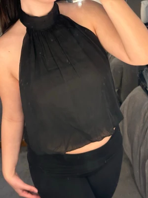 Svart halterneck topp i - Snygg svart halterneck topp i luftig och lätt polyester. Toppen är har aldrig används🫶🏻