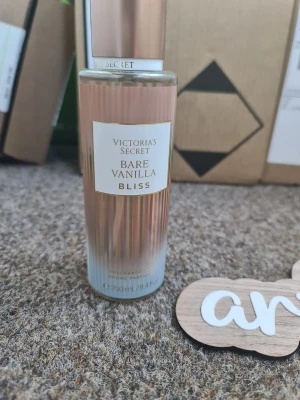 Victoria's Secret Bare Vanilla Bliss - Fräsch body mist från Victoria's Secret i doften Bare Vanilla Bliss. Flaskan är cylinderformad i glas med en snygg roséguldig och transparent design. Doften har inslag av vanilj och viol, perfekt för dig som gillar söta och blommiga toner. Innehåller 250 ml. Helt ny och oanvänd