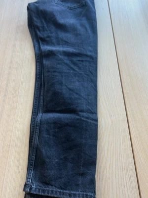Svarta jeans från Jack & Jones - Snygga svarta jeans från Jack & Jones med klassisk femficksmodell. Jeansen har en mörk tvätt och raka ben. Tillverkade i slitstarkt denimtyg som passar perfekt till en trendig vardagslook.