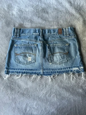 Lågmidjad kort Abercrombie&Fitch jeanskjol S - Supersnygg kort Lågmidjad jeanskjol från Abercrombie&Fitch i storlek 2, skulle säga S. Finns mått i bilderna, bra skick men passar tyvärr inte🩷
