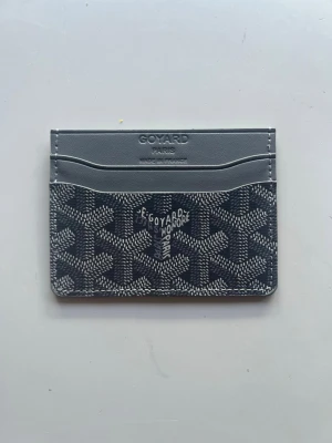 G*yard korthållare grå - Snyggt grått kortfodral från G*yard med klassiskt mönster och flera kortfack. Tillverkat i läder med G*yards logga präglad på framsidan. Perfekt för att hålla koll på dina kort med stil.