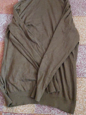 Brun stickad tröja från Dressmann - Mjuk och tunnstickad brun tröja från Dressmann i Supima bomull. Tröjan har rund halsringning, långa ärmar och ribbade muddar vid ärmslut och nederkant. Perfekt för lager på lager och enkel att matcha med jeans eller chinos.