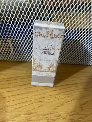 Pure Musk parfymolja - Elegant parfymolja från Khalis i doften Pure Musk. Flaskan kommer i en vit och guld dekorativ förpackning med orientaliskt mönster. Perfekt för dig som gillar fräscha och rena dofter med en lyxig touch.