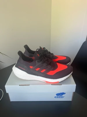 Adidas Ultraboost svarta/röda sneakers - Säljer ett par Adidas Ultraboost 21 - nypris : 3000kr - mitt pris : 2000kr / helt nya - oanvända 