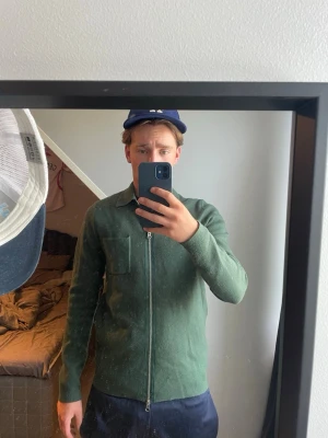 Grön ziptröja från Samsøe Samsøe  - Mörkgrön långärmad ziptröja från Samsøe Samsøe med klassisk krage och bröstficka.  Storlek S fint skick