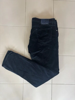 Jacob Cohen Jeans  - Snygga mörkblå manchesterbyxor från Jacob Cohen. Byxorna har en mjuk och skön känsla tack vare manchestertyget och passar perfekt för dig som gillar stilrena och tidlösa plagg. Detta är riktigt sällsynta cohens i en riktigt frän och speciell mörkblå färg, vilket gör detta till ett riktig kap! Badgen är dessutom svin fet. Längd - 110 cm och bredd - 50 cm 