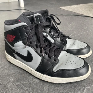 Nike Air Jordans Gray - Säljer ett par klassiska Nike Air Jordans i svart och grått med röda detaljer. Jag köpte skorna för 3-4 år sedan men har knappast använts så säljer dom. Vid snabb affär kan priset diskuteras, kan även visa undersida!!