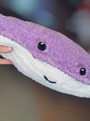 Lila stingrocka mjukisdjur - Supersöt mjukisdjur i form av en stingrocka med lila ovansida och vit undersida. Den har broderade ögon och ett litet leende, tillverkad i mjukt plyschmaterial. Perfekt som gosedjur eller dekoration i rummet.
