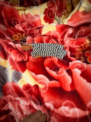 Svartvitt zigzag-mönstrat bälte - Elastiskt bälte i svartvitt zigzag-mönster med bruna läderdetaljer vid ändarna. Bältet är gjort av textil och läder, och ger en snygg kontrast till din outfit. Perfekt accessoar för att lyfta din stil.